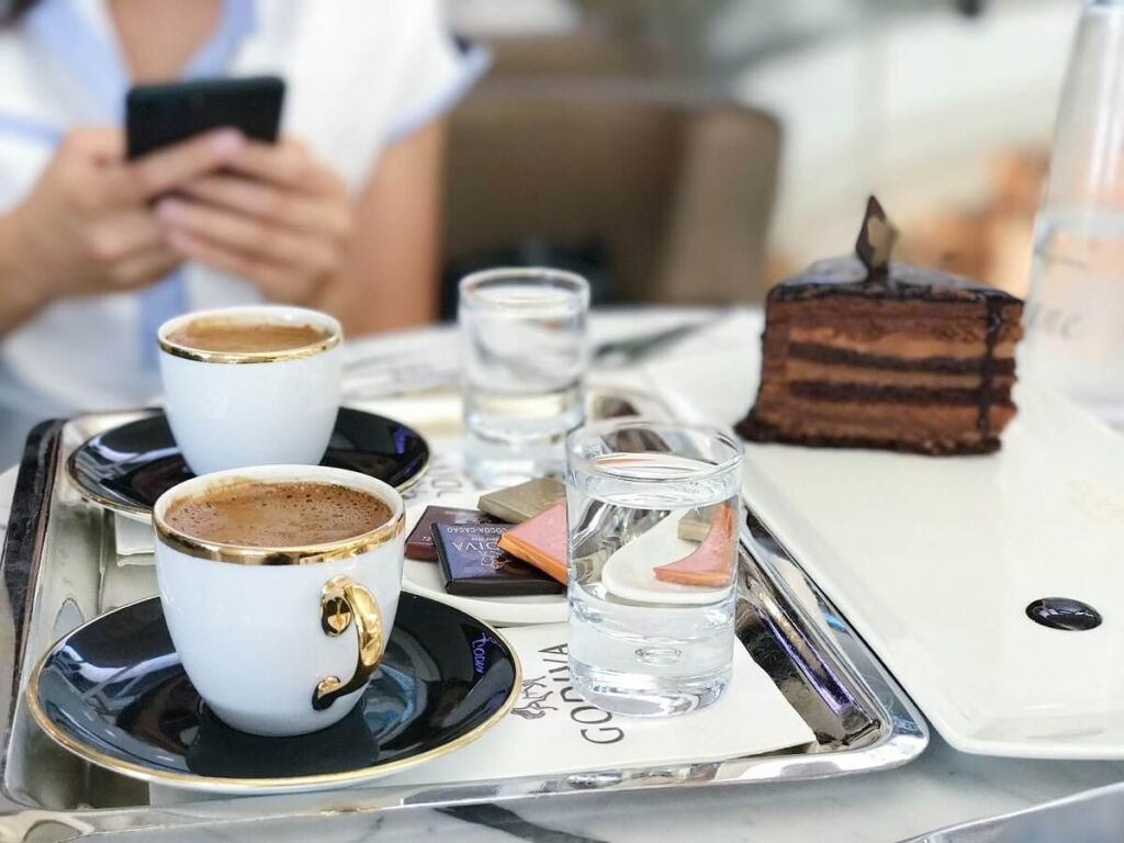 Traditional serving of Turkish coffee with a glass of water and a sweet